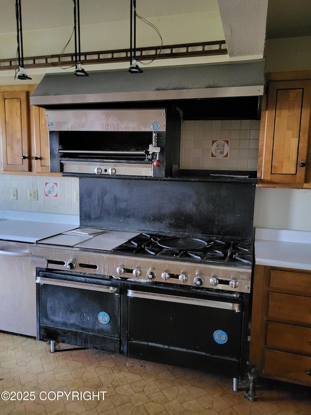 9921 Nearpoint Dr, Anchorage, AK 99507 - kitchen with double oven range, brown cabinetry, tasteful backsplash, and light countertops