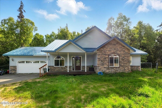 1708 Wesbet Ct, Kenai, AK 99611 - view of front of home with stone siding, an attached garage, driveway, a porch, and a front lawn
