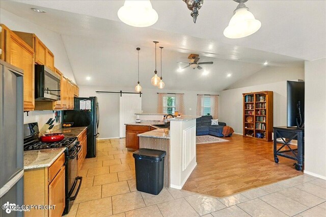 1708 Wesbet Ct, Kenai, AK 99611 - kitchen with black appliances, vaulted ceiling, ceiling fan, a large island with sink, and light tile patterned floors