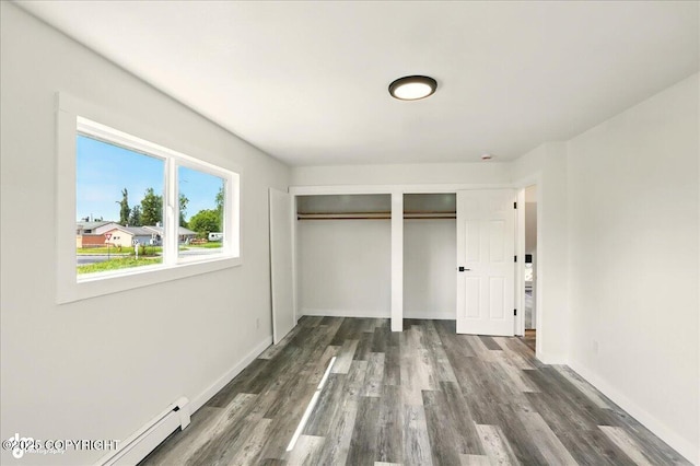 309 Stewart St, Anchorage, AK 99508 - unfurnished bedroom with multiple closets, a baseboard radiator, and dark wood-type flooring