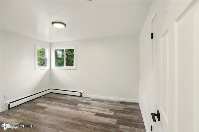 309 Stewart St, Anchorage, AK 99508 - empty room featuring wood finished floors and a baseboard heating unit