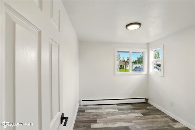 309 Stewart St, Anchorage, AK 99508 - empty room featuring a baseboard heating unit and wood finished floors