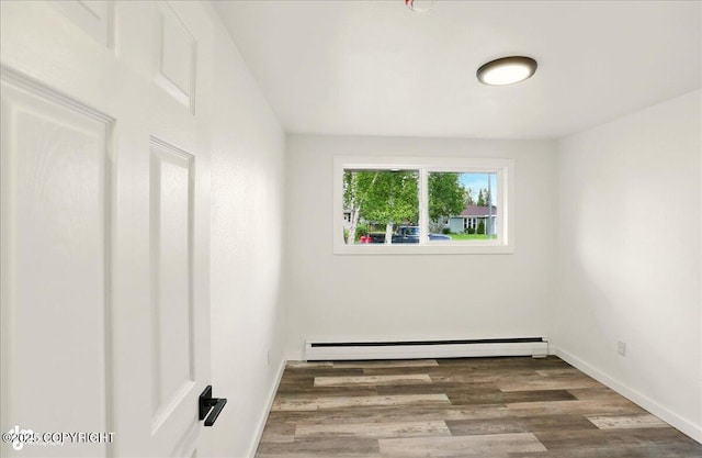 309 Stewart St, Anchorage, AK 99508 - spare room featuring a baseboard heating unit and wood finished floors