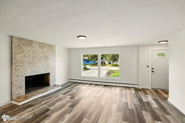 309 Stewart St, Anchorage, AK 99508 - unfurnished living room featuring a baseboard heating unit, a large fireplace, and wood finished floors