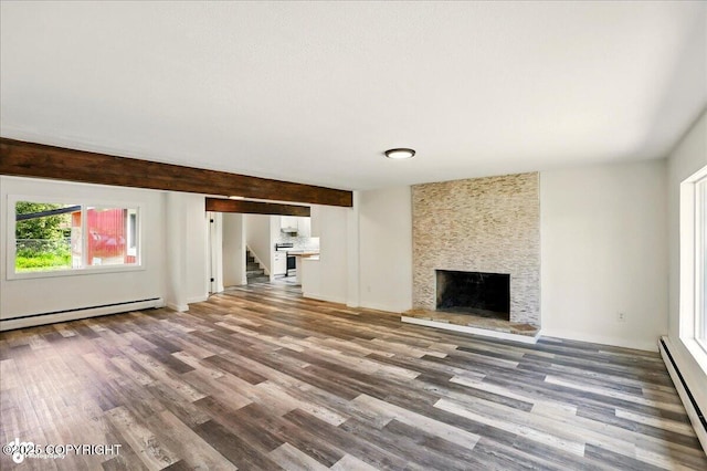 309 Stewart St, Anchorage, AK 99508 - unfurnished living room with baseboard heating, wood finished floors, stairway, and a large fireplace