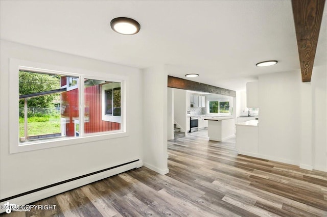 309 Stewart St, Anchorage, AK 99508 - empty room with a baseboard heating unit, wood finished floors, and stairs