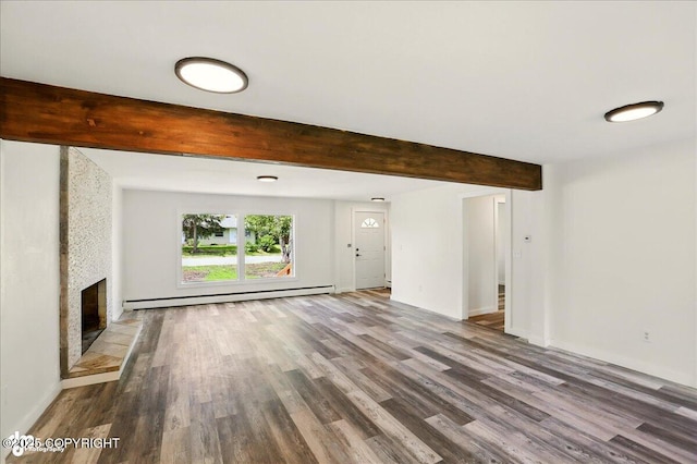 309 Stewart St, Anchorage, AK 99508 - unfurnished living room with a baseboard radiator, wood finished floors, beam ceiling, and a large fireplace