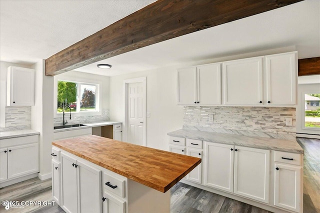 309 Stewart St, Anchorage, AK 99508 - kitchen with wood finished floors, backsplash, butcher block counters, and beamed ceiling