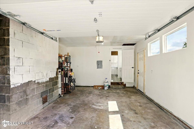 309 Stewart St, Anchorage, AK 99508 - garage featuring a garage door opener, electric panel, and concrete block wall