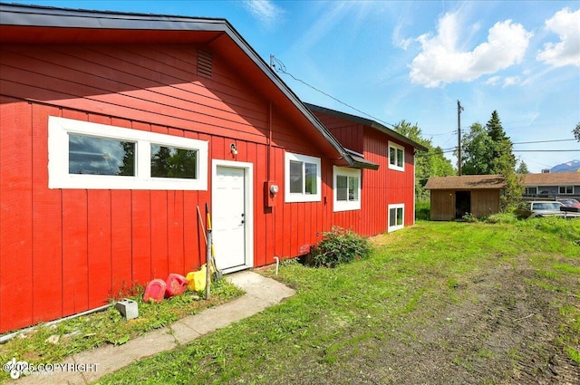 309 Stewart St, Anchorage, AK 99508 - view of side of property featuring board and batten siding, an outbuilding, and a lawn