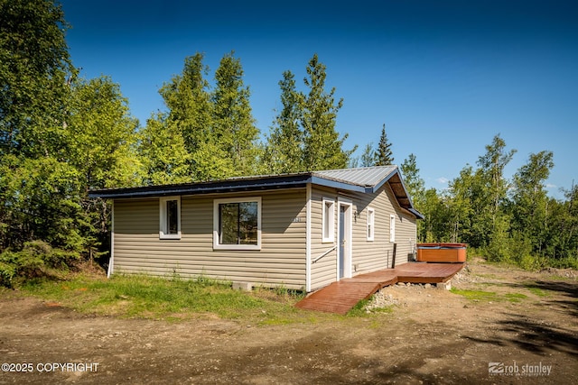 3521 N Caribou St, Wasilla, AK 99654 - view of home's exterior with a hot tub, a wooden deck, and a metal roof