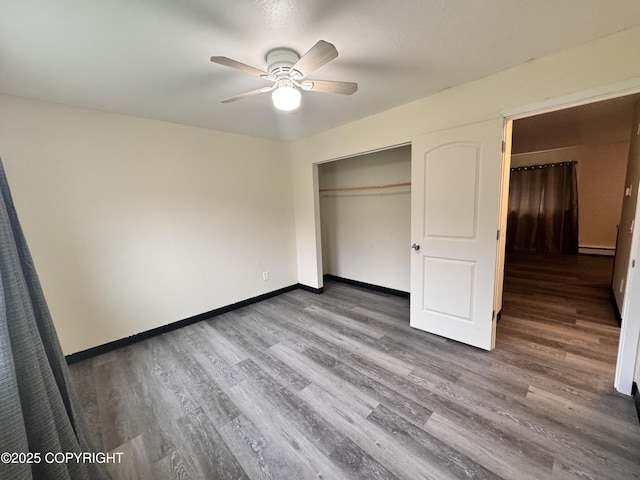 544 N Park St, Anchorage, AK 99508 - unfurnished bedroom with wood finished floors, a baseboard heating unit, a closet, and ceiling fan