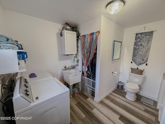 1245 N Miller Cir, Houston, AK 99623 - washroom featuring washer and dryer, light wood-style flooring, and a textured ceiling