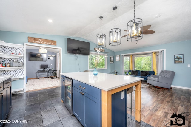3501 N Calder Rd, Wasilla, AK 99654 - kitchen with wine cooler, blue cabinetry, healthy amount of natural light, lofted ceiling, and light countertops