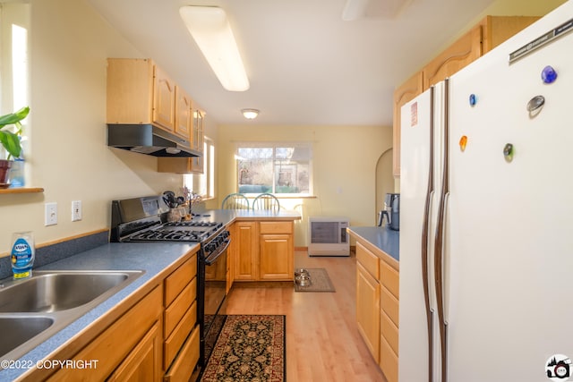 12230 Nautical Ave, Seward, AK 99664 - kitchen with freestanding refrigerator, gas stove, under cabinet range hood, light wood-style flooring, and light brown cabinets