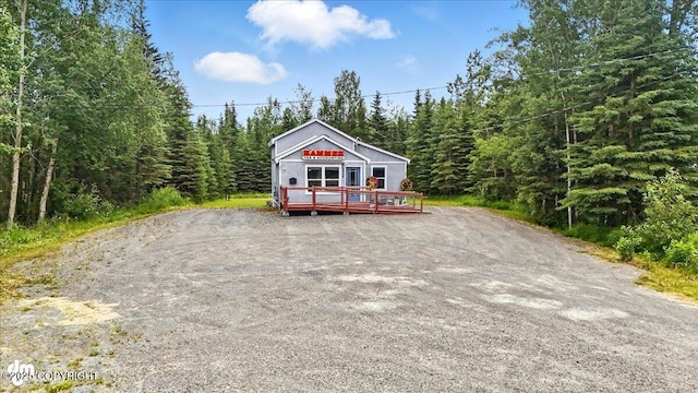 5968 Kenai Spur Highway, Kenai, AK 99611 - rustic home with a wooden deck and a view of trees