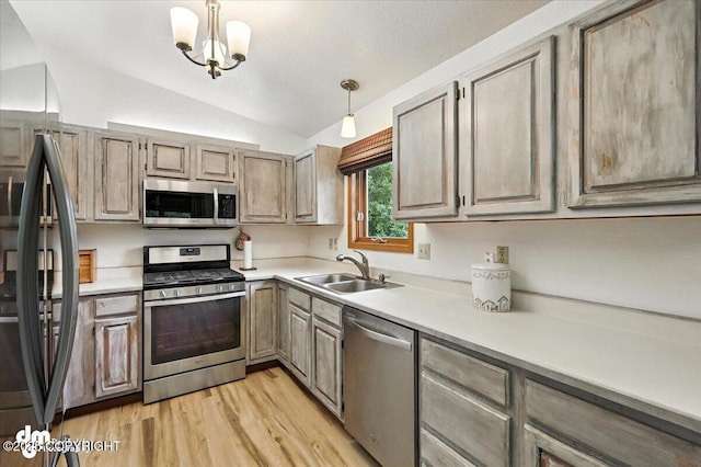 3800 E Birch View Dr, Wasilla, AK 99654 - kitchen with stainless steel appliances, lofted ceiling, light wood-style floors, light countertops, and hanging light fixtures