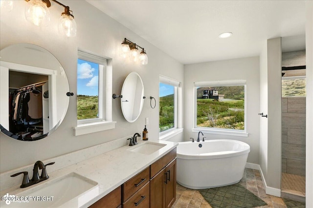 10380 Honey Bear Ln, Anchorage, AK 99516 - full bathroom with a soaking tub, double vanity, stone finish floors, a tile shower, and a spacious closet