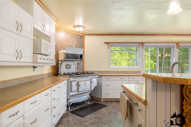 1160 E Susitna Dr, Wasilla, AK 99654 - kitchen featuring white microwave, high end range, white cabinets, and backsplash