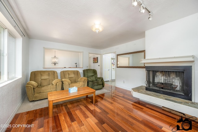 1160 E Susitna Dr, Wasilla, AK 99654 - living room with wood finished floors, a fireplace with raised hearth, a textured ceiling, and track lighting
