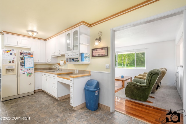1160 E Susitna Dr, Wasilla, AK 99654 - kitchen featuring white refrigerator with ice dispenser, light countertops, white cabinetry, wainscoting, and glass insert cabinets