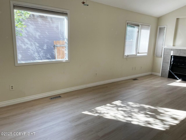 4310 Ambler Cir, Anchorage, AK 99504 - unfurnished living room with a tile fireplace, wood finished floors, and vaulted ceiling