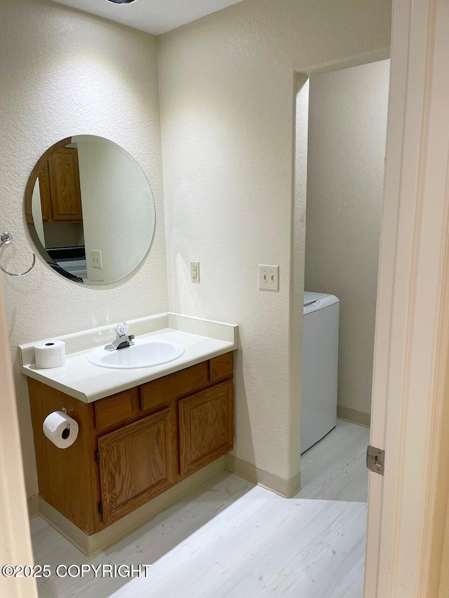 4310 Ambler Cir, Anchorage, AK 99504 - half bath featuring wood finished floors, vanity, a textured wall, and washer / clothes dryer