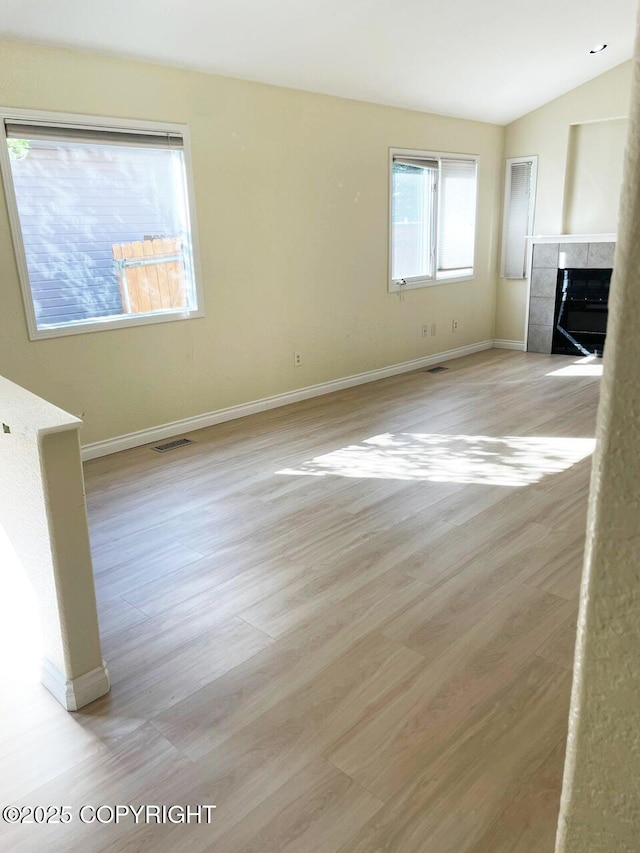 4310 Ambler Cir, Anchorage, AK 99504 - unfurnished living room with light wood-style floors, a fireplace, and vaulted ceiling