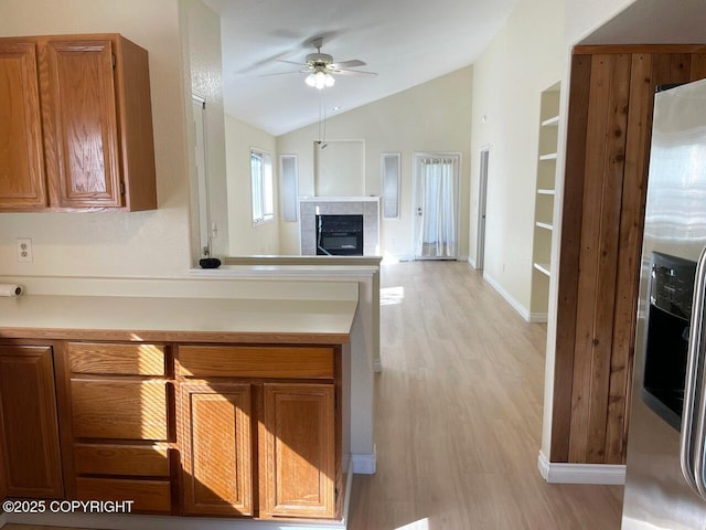 4310 Ambler Cir, Anchorage, AK 99504 - kitchen with stainless steel refrigerator with ice dispenser, vaulted ceiling, ceiling fan, light countertops, and light wood finished floors