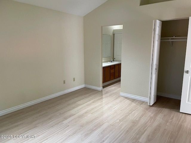 4310 Ambler Cir, Anchorage, AK 99504 - unfurnished bedroom featuring lofted ceiling, light wood-style floors, a closet, and connected bathroom