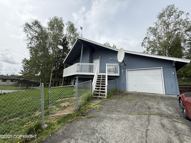 1140 Lalande Pl, Anchorage, AK 99504 - view of front of home with an attached garage, stairway, asphalt driveway, and a wooden deck