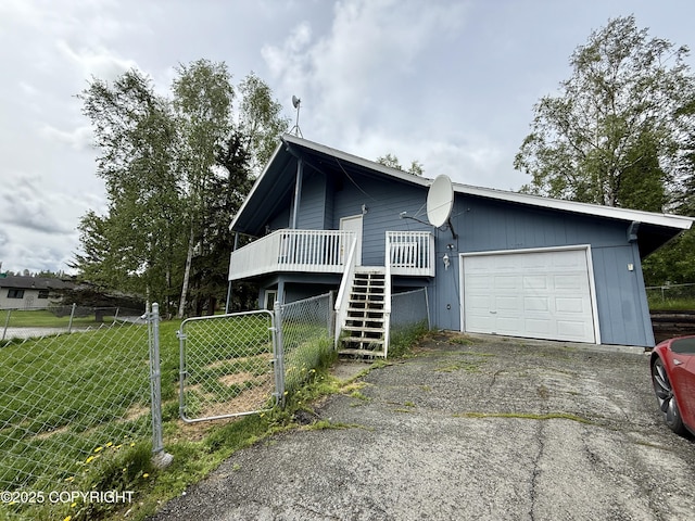 1140 Lalande Pl, Anchorage, AK 99504 - view of front of house with an attached garage, driveway, stairs, and a deck