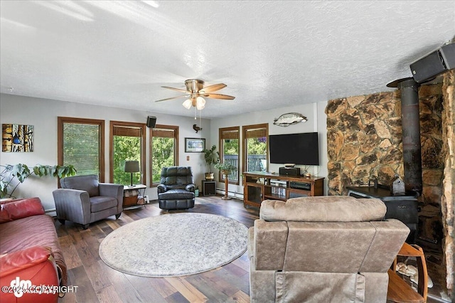 19360 Chugach Park Dr, Chugiak, AK 99567 - living area with a ceiling fan, wood finished floors, baseboard heating, a textured ceiling, and a wood stove