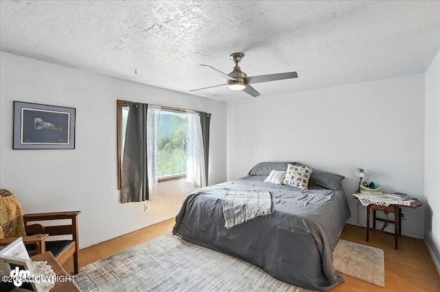 19360 Chugach Park Dr, Chugiak, AK 99567 - bedroom with wood finished floors, a textured ceiling, and a ceiling fan