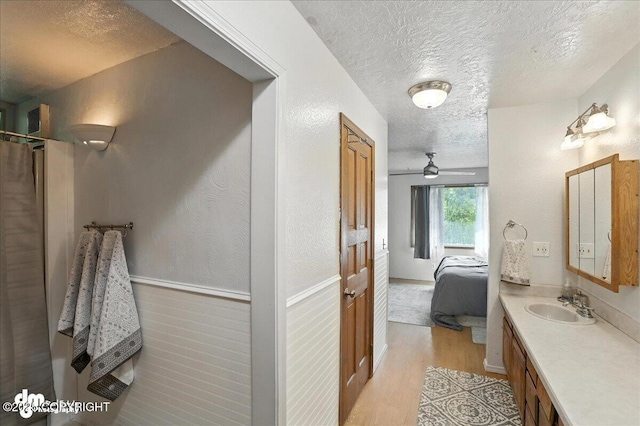 19360 Chugach Park Dr, Chugiak, AK 99567 - full bathroom featuring a textured ceiling, ensuite bathroom, vanity, wood finished floors, and ceiling fan