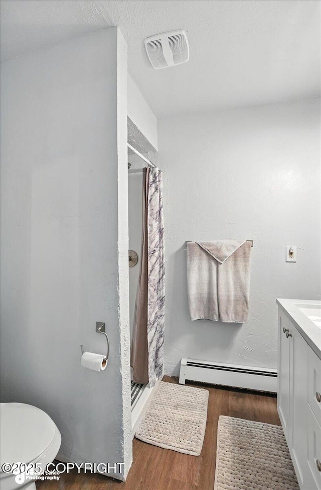 19360 Chugach Park Dr, Chugiak, AK 99567 - full bath featuring a baseboard heating unit, wood finished floors, and a stall shower