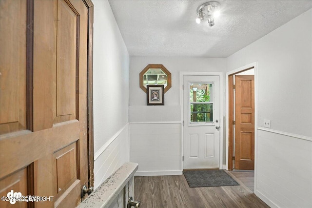 19360 Chugach Park Dr, Chugiak, AK 99567 - foyer entrance featuring a textured ceiling, a wainscoted wall, and dark wood finished floors