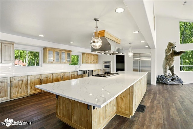 5100 W Lakeside Dr, Wasilla, AK 99654 - kitchen with ventilation hood, a spacious island, appliances with stainless steel finishes, tasteful backsplash, and healthy amount of natural light