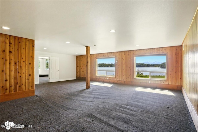 5100 W Lakeside Dr, Wasilla, AK 99654 - unfurnished living room featuring carpet flooring, wood walls, a water view, and recessed lighting