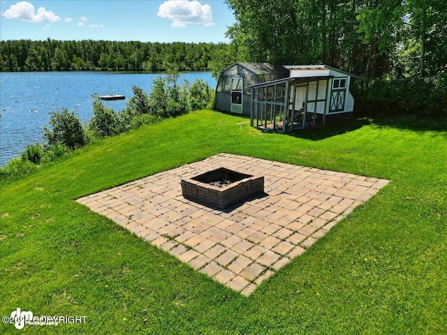 5100 W Lakeside Dr, Wasilla, AK 99654 - view of grassy yard with an outdoor fire pit, a patio area, a water view, exterior structure, and an outbuilding
