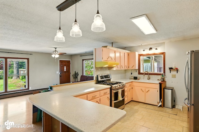 3401 Lois Dr, Anchorage, AK 99517 - kitchen with stainless steel appliances, a peninsula, under cabinet range hood, light countertops, and a textured ceiling