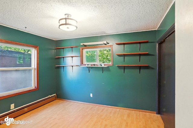 3401 Lois Dr, Anchorage, AK 99517 - spare room featuring a baseboard radiator, a textured ceiling, and wood finished floors