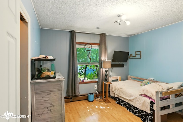 3401 Lois Dr, Anchorage, AK 99517 - bedroom featuring wood finished floors, a textured ceiling, and baseboard heating