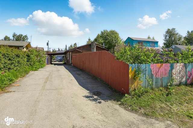 3401 Lois Dr, Anchorage, AK 99517 - view of side of property featuring asphalt driveway and a carport