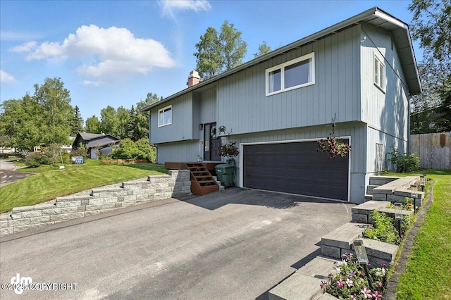 13481 Baywind Dr, Anchorage, AK 99516 - raised ranch featuring an attached garage, a chimney, and asphalt driveway