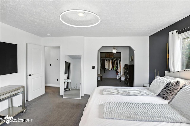 13481 Baywind Dr, Anchorage, AK 99516 - carpeted bedroom featuring arched walkways, a walk in closet, a textured ceiling, and a closet