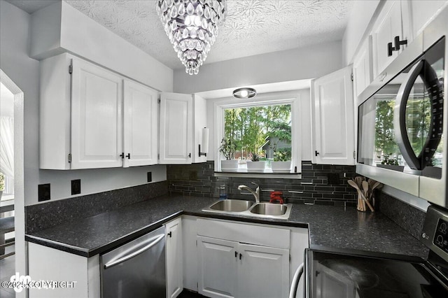 13481 Baywind Dr, Anchorage, AK 99516 - kitchen with stainless steel appliances, white cabinetry, decorative backsplash, and a textured ceiling