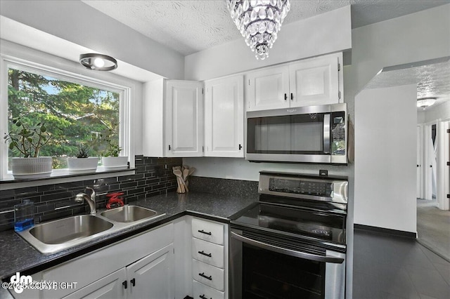 13481 Baywind Dr, Anchorage, AK 99516 - kitchen featuring appliances with stainless steel finishes, white cabinets, a textured ceiling, dark countertops, and backsplash