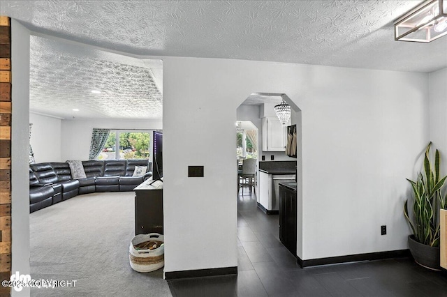 13481 Baywind Dr, Anchorage, AK 99516 - living area featuring arched walkways, a textured ceiling, and dark tile patterned floors
