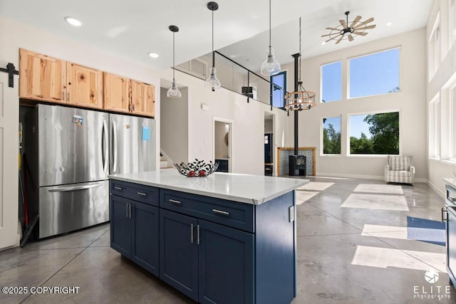 4722 S Gon Fishin Dr, Wasilla, AK 99623 - kitchen with freestanding refrigerator, a wood stove, concrete floors, recessed lighting, and hanging light fixtures